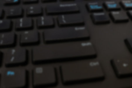 Blurred background of computer keyboard, shallow depth of field, selective focus.