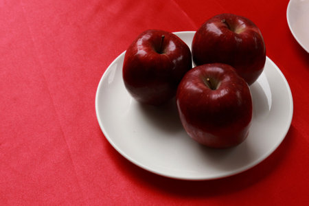 Photo of three fresh apples on the tableの写真素材