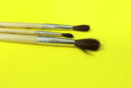 Paint brushes on a yellow background. Top view. Copy space.の写真素材
