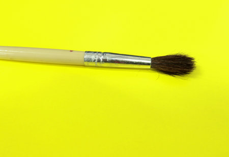 Paint brush on a yellow background. Close-up shot.の写真素材