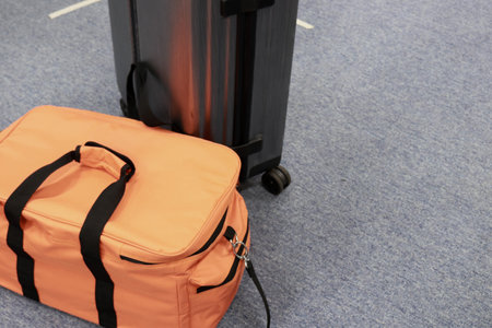 Orange bag on the floor in airport terminal, closeup of photoの写真素材