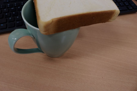 A cup with a slice of bread on top.の写真素材