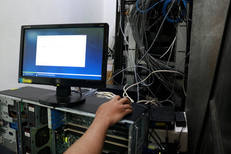 : A repairman in the server room repairs server computers, networks and cablesの写真素材