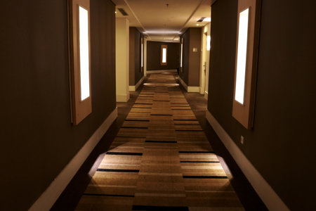 Interior of a hotel corridor with wooden floor and light at nightの写真素材