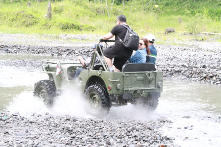 Unidentified tourists driving 4x4 vehicle on the river.の写真素材