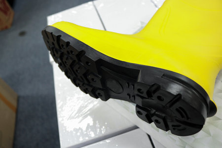 Yellow rubber boots that are waterproof are usually worn by construction workers, to protect their feet from work accidents, such as impact of hard objects, chemicals, toxic liquidの写真素材