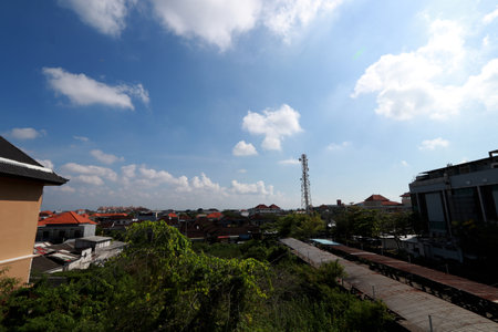 View of a city with clear blue sky and white cloudsの写真素材