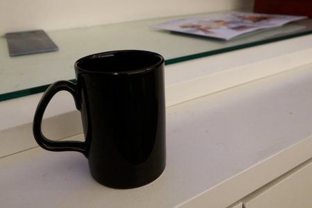 Photo of a blue electric kettle and two black cups or mugs for coffee, tea or hot cocoaの写真素材
