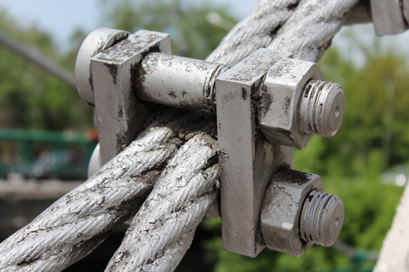 Large bolts, nuts and steel wire rope. Elements of fastening of bridge.の写真素材