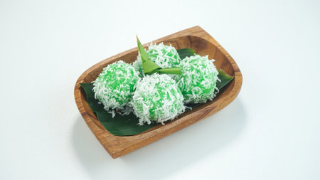 Kelepon cake or klepon is a traditional food from Indonesia made of glutinous rice flour brown sugar grated coconut served in a plate isolated on bright white background. Close upの写真素材
