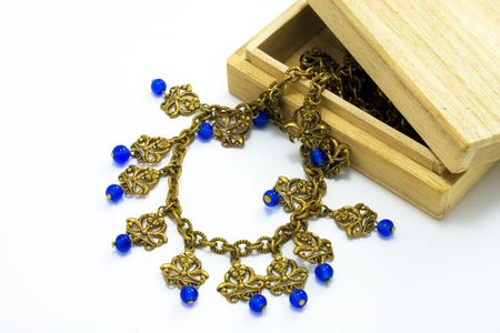 Wooden box, vintage gold necklace with blue beads insideの写真素材