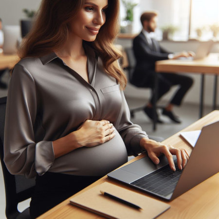 Beautiful pregnant woman working on laptop in office. Business people in the backgroundの素材