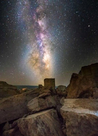 Milky Way over the rocks and the ruins of an ancient castle