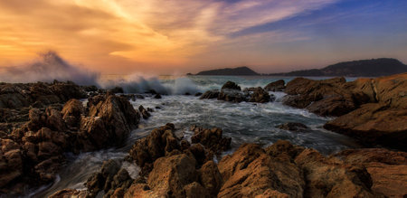 Beautiful seascape with waves crashing on the rocks at sunset