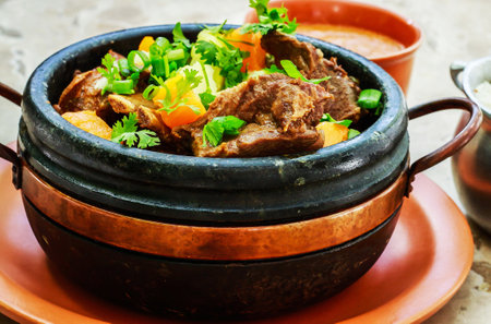 beef stew with carrot and parsley in a clay pot.の写真素材