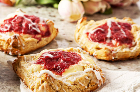 Freshly baked pastries with raspberry jam on a baking paper.の写真素材