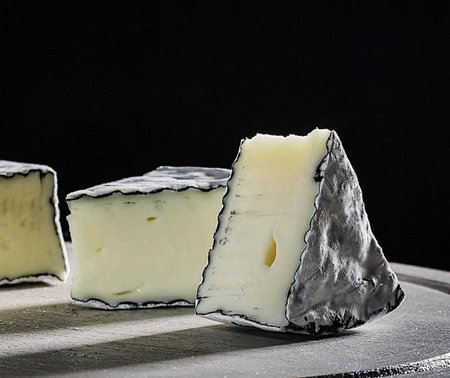 Camembert cheese on a black background. Selective focus.の写真素材