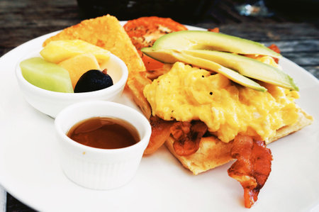 Breakfast with scrambled eggs and fruit on wooden table, Thailand.の写真素材
