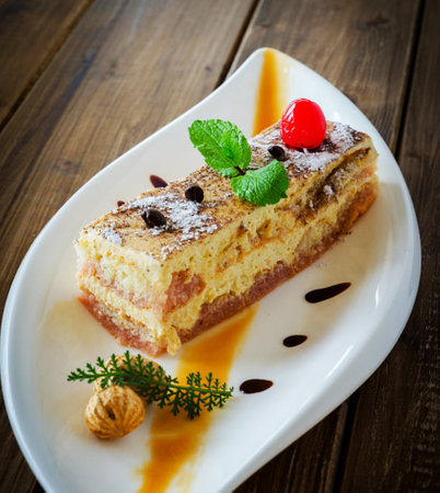 tiramisu cake on a white plate on a wooden table