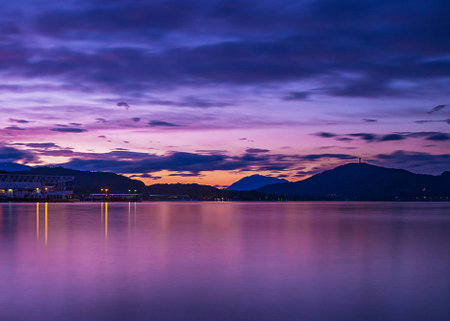 Sunset on the lake with mountains in the background in the eveningの写真素材