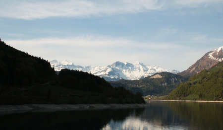 Mountain landscape with lake and snow-capped Alps in Switzerlandの写真素材