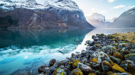Mountain landscape with lake and snow-capped peaks in Norwayの写真素材