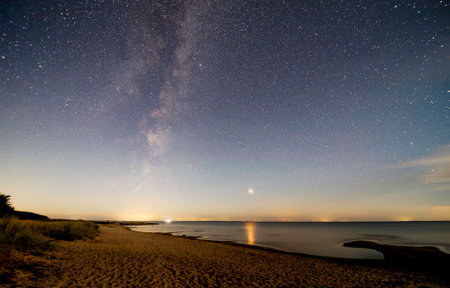 Night sky with stars and milky way over the sea. Long exposure.