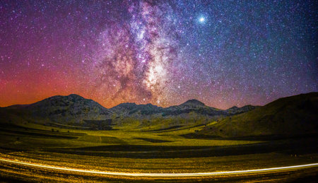 Milky Way over the mountain and highway in Tibet, China.の写真素材