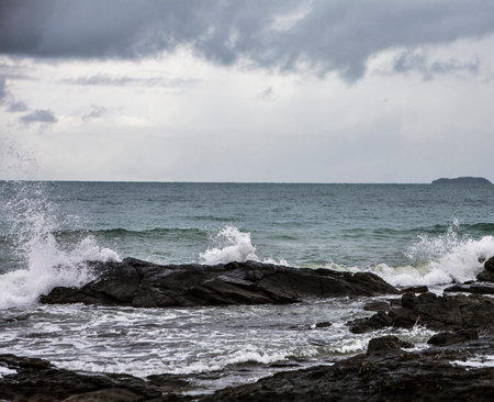 Stormy seascape with waves crashing on the rocks in the foreground