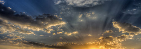 Sunset sky with clouds and sun rays. Panoramic view.