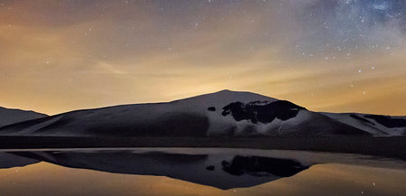 Mountain landscape with starry sky and lake at night, Iceland