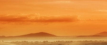 Foggy sunrise over the hills. Panoramic view.