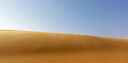 Desert sand dunes and blue sky in Dubai, United Arab Emirates