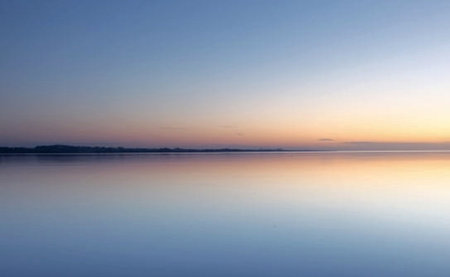 Sunset on the lake with reflection in the water and blue skyの写真素材