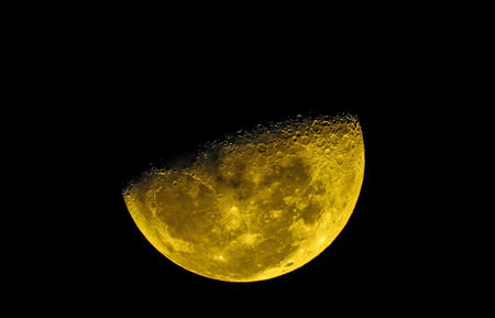 Close up of a yellow moon at night with a black background.の写真素材