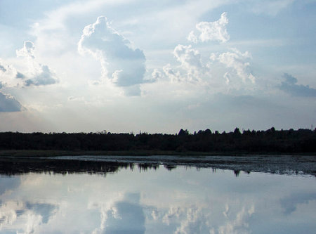 Reflection of clouds and sky in the lake. Beautiful nature background.