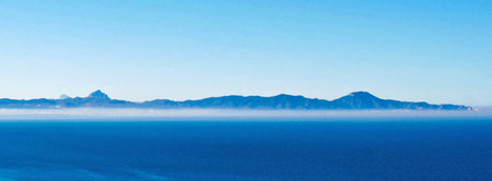 Panoramic view of the sea and mountains in the mist.の写真素材