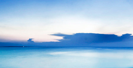 Beautiful seascape at sunset time. Blue sky and white cloudsの写真素材