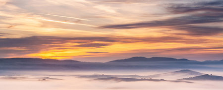 Panoramic view of foggy morning in the mountains at sunrise.