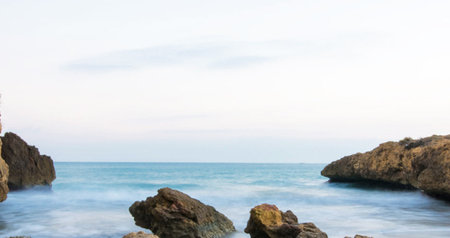 Panorama of the sea and rocks on the beach at sunset.の写真素材