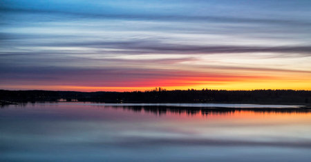 Sunset over the lake. Beautiful landscape with a lake in the foreground.の写真素材