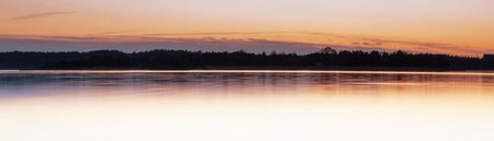 Beautiful sunset on the lake. Panoramic view of the lake.の写真素材
