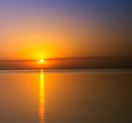 Sunset over the sea with reflection in water. Beautiful nature background.の写真素材