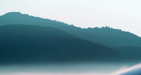 Beautiful landscape of foggy mountain lake in the early morning.
