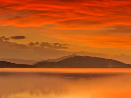 Beautiful sunset in the mountains reflected in the water of the lakeの写真素材