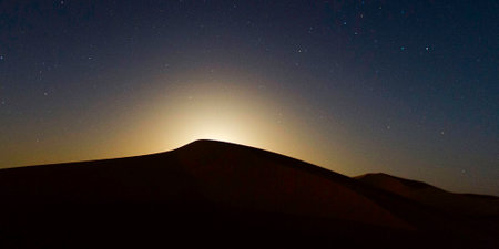 Moon rising over the dunes of the Sahara desert in Morocco.の写真素材