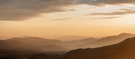 Mountains in the fog at sunset. Panoramic view.の写真素材