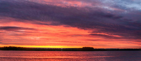 Beautiful sunset over the lake in Finland. Panoramic view.