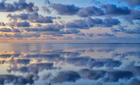 Reflection of clouds in the sea at sunset. Natural background.