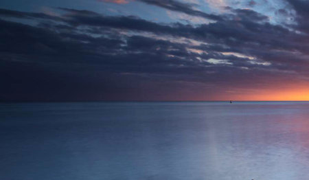 Beautiful sunset over the sea. Dramatic sky. Long exposure.